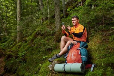 Turistik haritalar Smartphone ormandaki arıyorum genç adam.