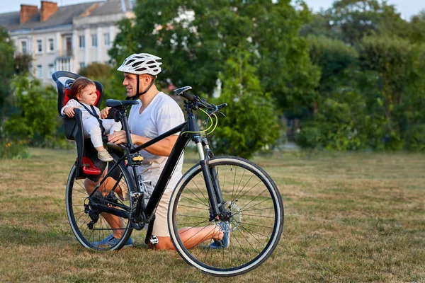Милая девушка на велосипеде сиденье велосипеда с отцом в городе — стоковое фото