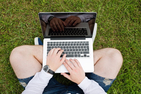 Businessman working with a laptop on the grass