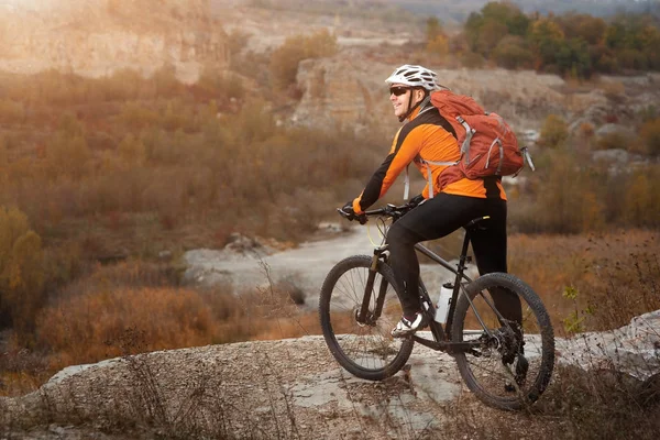 Mountain biking down the trail. Tourist with backpack travel on bike.