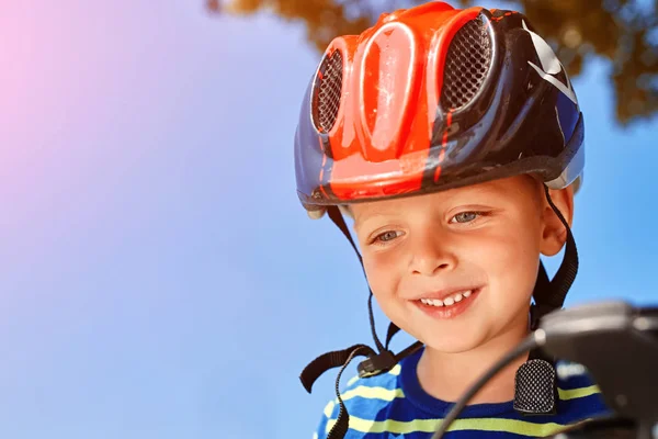 Kid with a helmet laughs happily at the park — Stock Photo, Image