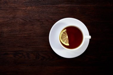 Beyaz fincan limonlu çay, tarçın sopa, ahşap masa üzerinde yün atkı örme