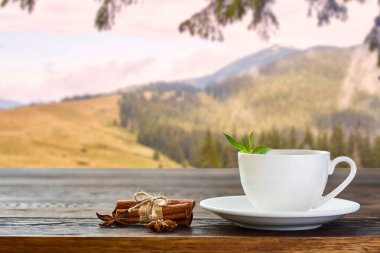 Dağların tepesinde çay fincanı ve güneş ışığı. Güzellik doğası