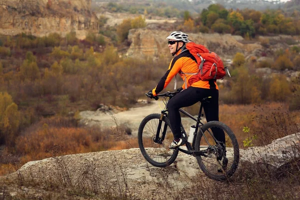 Hombre en ropa deportiva saltando alto en bicicleta de montaña en el fondo del paisaje . — Foto de Stock