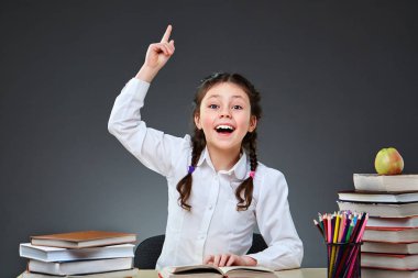 Şirin çalışkan çocuk kapalı masa başında oturuyor. Çocuk sınıf içinde yazı tahtası üzerinde arka plan öğrenme.