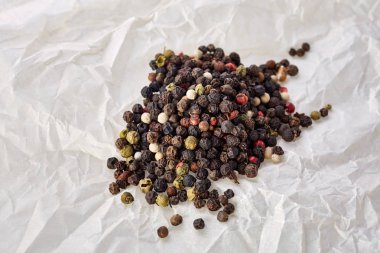 kara biber tatlı kokulu bezelye beyaz buruşuk kağıt üzerinde toplu olarak. Üstten Görünüm