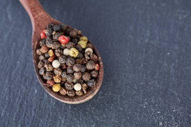 Çince biber, tahta kaşık siyah arduvaz taş plaka üzerinde Sichuan biber