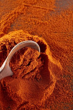 Doku arka plan. Kırmızı biber biber toz tahta kaşıkla karıştırılarak. Üstten Görünüm