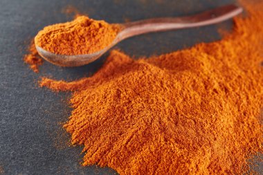 Doku arka plan. Kırmızı biber biber toz tahta kaşıkla karıştırılarak. Üstten Görünüm