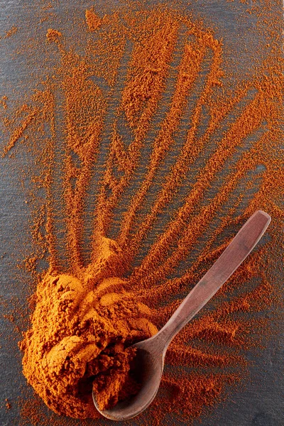Υφή φόντου. Κόκκινο τσίλι πιπέρι σε σκόνη αναμιγνύεται με ξύλινο κουτάλι. Το Top view — Φωτογραφία Αρχείου