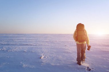 Dağcı tepeye bir buzulun üzerinde yürür. Dikiz, arka ışık, soldaki büyük kopya alanı.