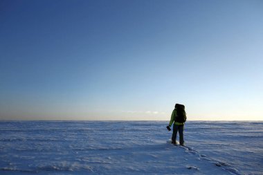 Dağcı tepeye bir buzulun üzerinde yürür. Dikiz, arka ışık, soldaki büyük kopya alanı.