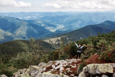 Bir kayalık dağ tepe üzerinde el ile ayakta uzun yürüyüşe çıkan kimse kadın.