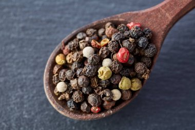 bir taş zemin üzerine bir kaşık karabiber bezelye