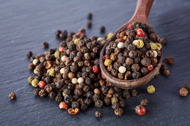 bir taş zemin üzerine bir kaşık karabiber bezelye