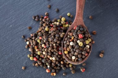 bir taş zemin üzerine bir kaşık karabiber bezelye