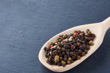 bir taş zemin üzerine bir kaşık karabiber bezelye