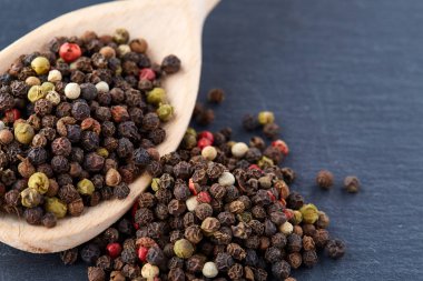 bir taş zemin üzerine bir kaşık karabiber bezelye