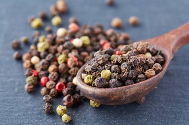 bir taş zemin üzerine bir kaşık karabiber bezelye