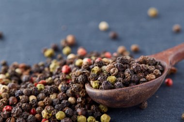 bir taş zemin üzerine bir kaşık karabiber bezelye