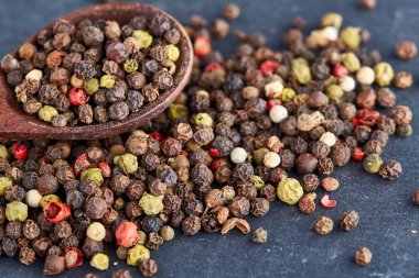 bir taş zemin üzerine bir kaşık karabiber bezelye