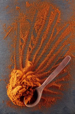 Doku arka plan. Kırmızı biber biber toz tahta kaşıkla karıştırılarak. Üstten Görünüm