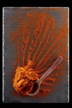 Doku arka plan. Kırmızı biber biber toz tahta kaşıkla karıştırılarak. Üstten Görünüm