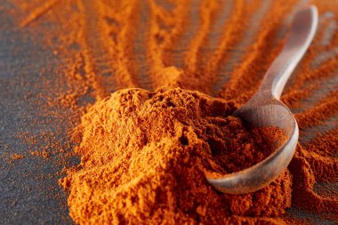 Doku arka plan. Kırmızı biber biber toz tahta kaşıkla karıştırılarak. Üstten Görünüm