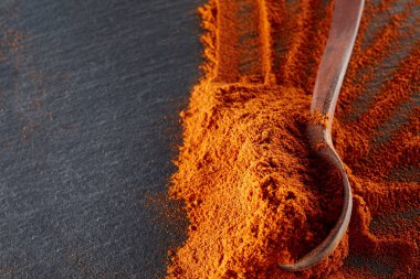 Doku arka plan. Kırmızı biber biber toz tahta kaşıkla karıştırılarak. Üstten Görünüm