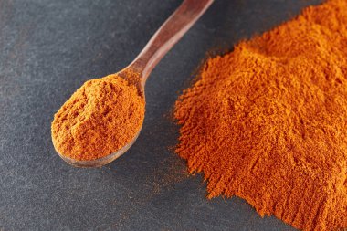 Doku arka plan. Kırmızı biber biber toz tahta kaşıkla karıştırılarak. Üstten Görünüm