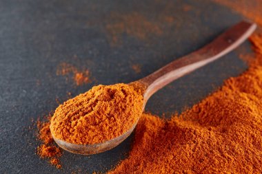 Doku arka plan. Kırmızı biber biber toz tahta kaşıkla karıştırılarak. Üstten Görünüm