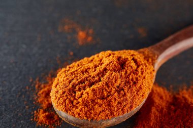 Doku arka plan. Kırmızı biber biber toz tahta kaşıkla karıştırılarak. Üstten Görünüm