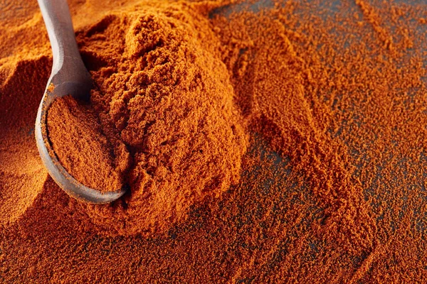 Υφή φόντου. Κόκκινο τσίλι πιπέρι σε σκόνη αναμιγνύεται με ξύλινο κουτάλι. Το Top view — Φωτογραφία Αρχείου