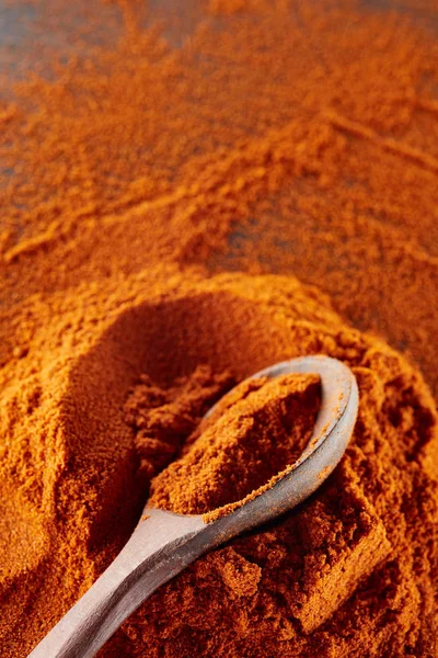 Textuur achtergrond. Rode chili peper poeder gemengd met houten lepel. Bovenaanzicht — Stockfoto