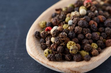 bir taş zemin üzerine bir kaşık karabiber bezelye