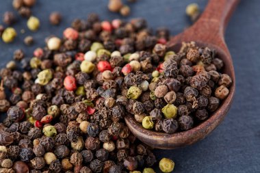 bir taş zemin üzerine bir kaşık karabiber bezelye