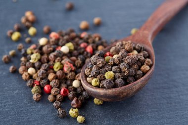 bir taş zemin üzerine bir kaşık karabiber bezelye