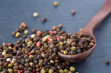 bir taş zemin üzerine bir kaşık karabiber bezelye