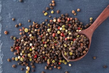 bir taş zemin üzerine bir kaşık karabiber bezelye