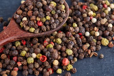 bir taş zemin üzerine bir kaşık karabiber bezelye