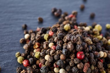 Siyah, kırmızı ve beyaz karabiber koyu arka plan üzerine sığ derinlik-in tarla izole üzerinde Üstten Görünüm.