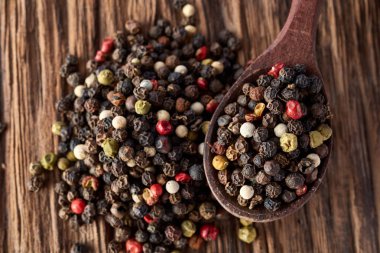 Ahşap arka plan üzerine sığ derinlik-in tarla, ön odak izole yenibahar tohumların tam bir tahta kaşıkla Üstten Görünüm