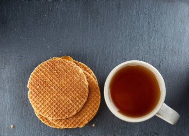 Top görünümünde bir fincan çay ve tanımlama karanlık bir arka plan üzerinde izole yakın çekim