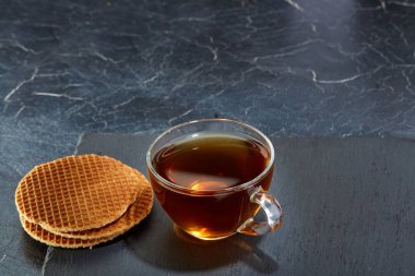 Siyah çay waffle koyu grimsi mermer zemin ile cam fincan. Kahvaltı arka plan