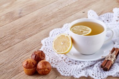 Gurme çay bardağı limon, tarçın ve örme peçeteye lezzetli muffins