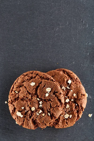 Biscuits aux pépites de chocolat isolés sur fond noir, macro, gros plan, vertical — Photo