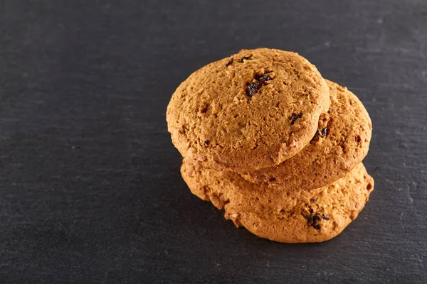 Biscuits aux pépites de chocolat isolés sur fond noir, macro, gros plan, faible profondeur de champ — Photo