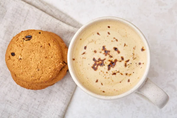 Cup of coffee and biscuit isolated on the white background, close-up, top view, shallow depth of field.