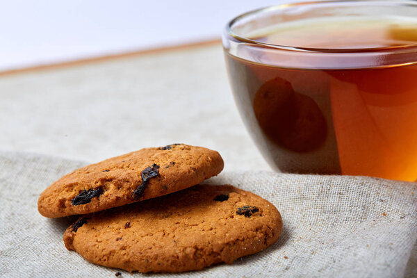 Top view close up picture of glass teacup with biscuits isolated on white background, frontfocus, shallow depth of field