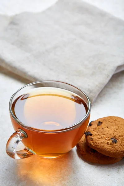 Närbild på te i glas cup med kex cookies isolerad på vit bakgrund, vertikal, främre fokus — Stockfoto